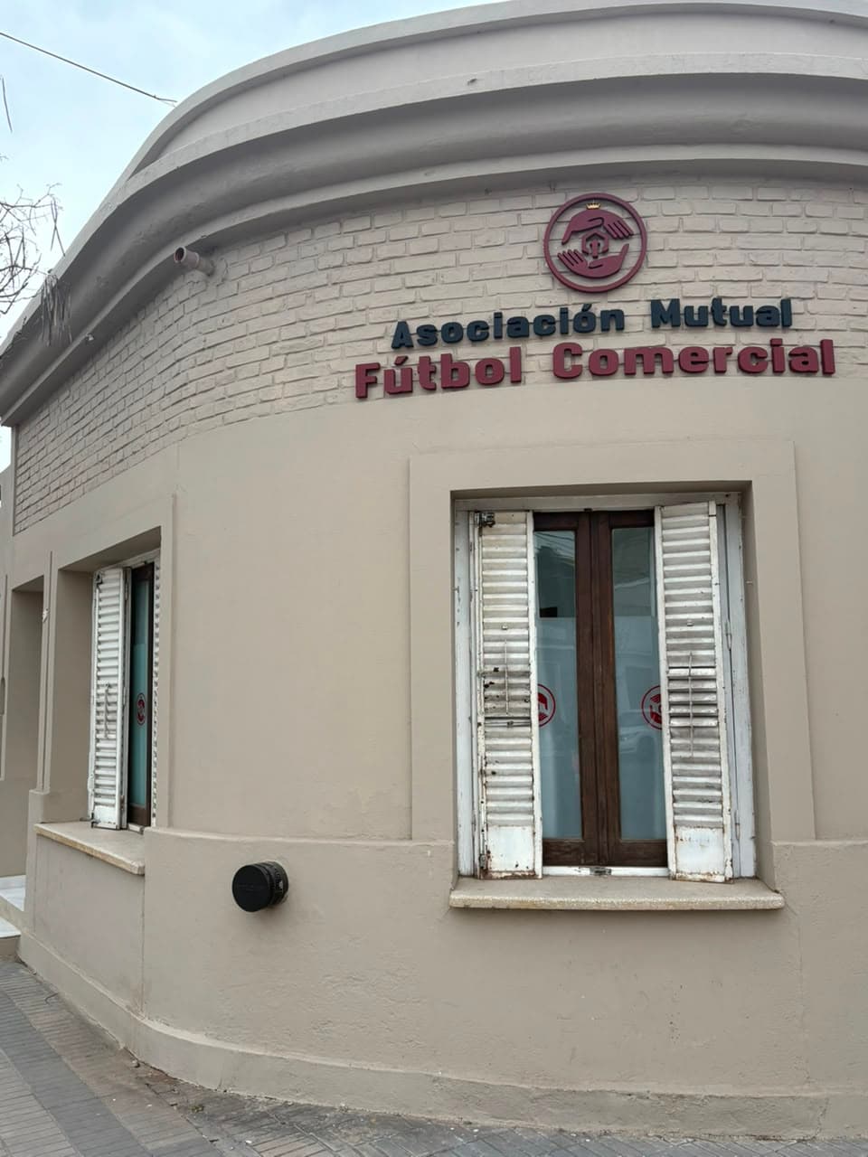 Frente de la sede de Mutual AFUCO en Villa María, con sus ventanas de postigos y el cartel institucional.